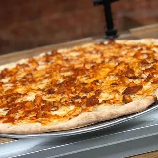 A freshly baked buffalo chicken pizza sits on a metal tray.