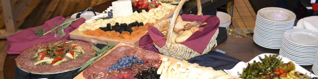 An overhead shot of a charcuterie board with cheeses, meats, fruit, and bread.