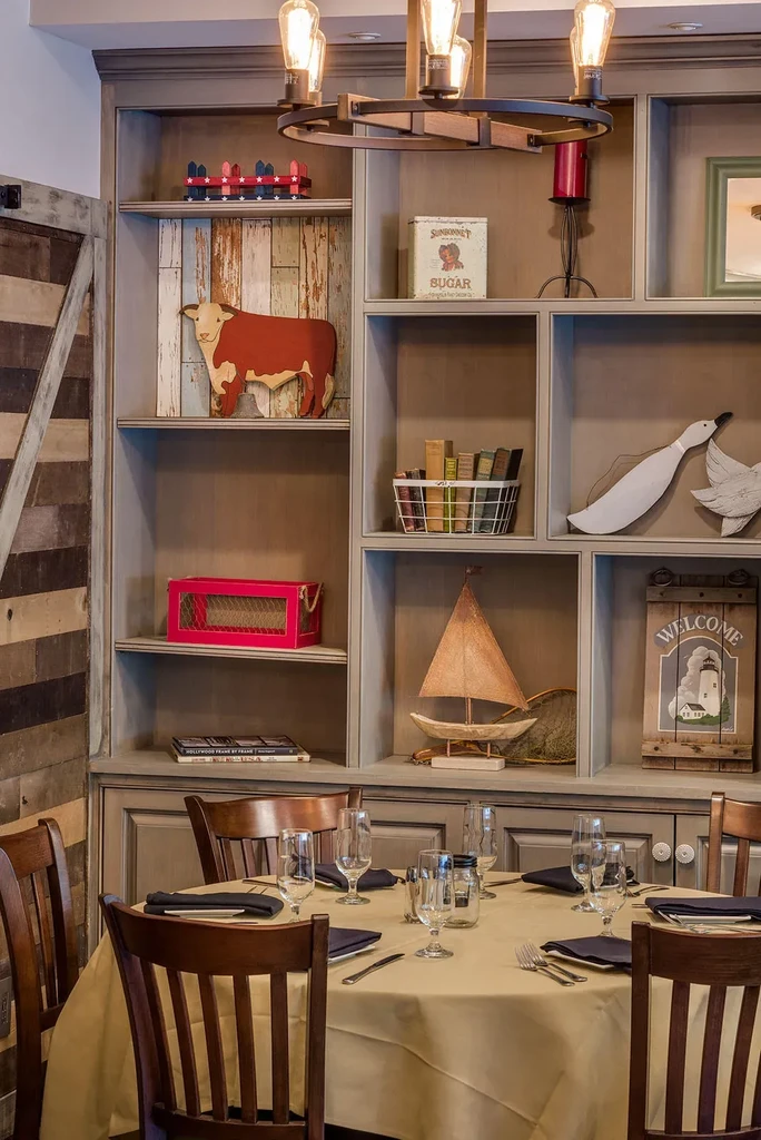 Cozy dining area with a set table and rustic shelves.