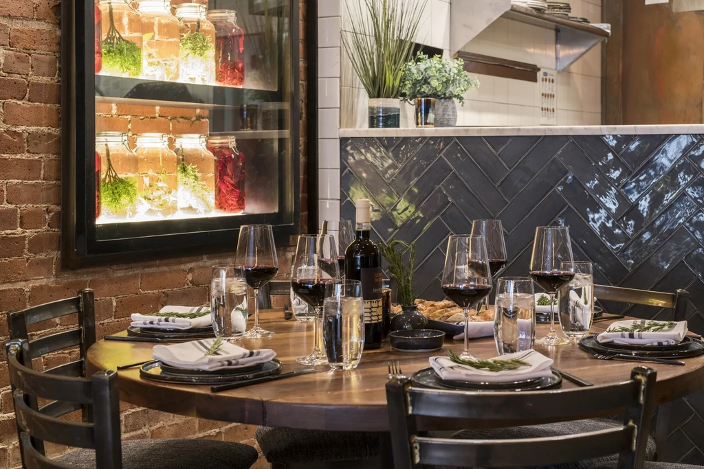 A set table in a rustic restaurant with exposed brick walls.