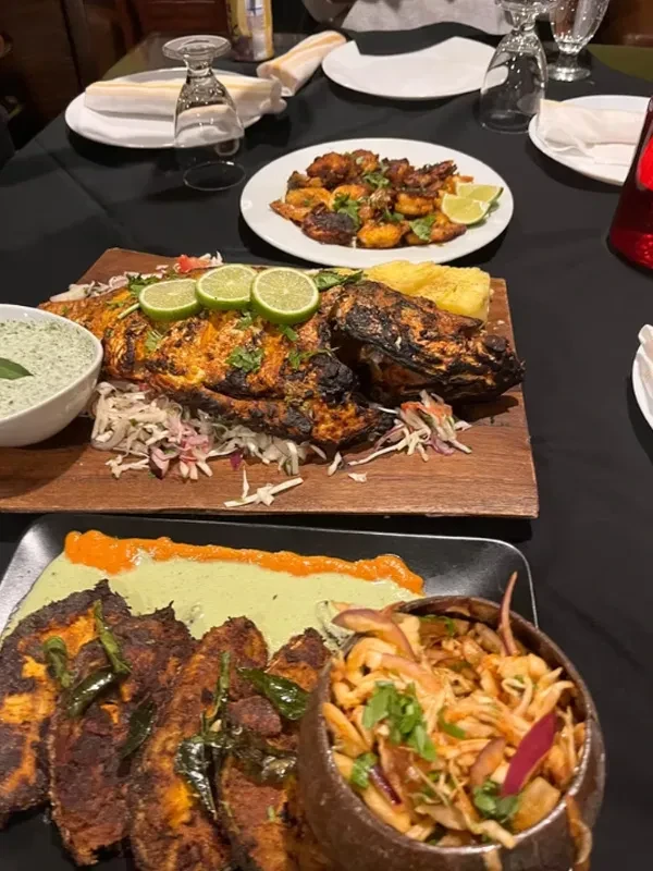 A table laden with a variety of grilled seafood and sides.