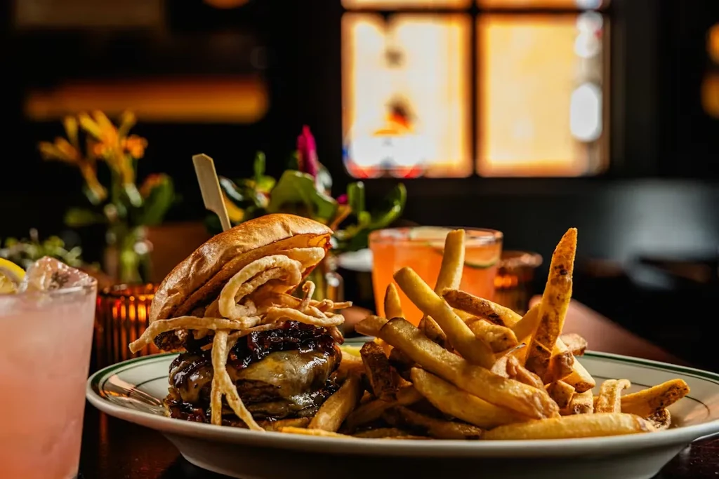 Gourmet burger and hand-cut fries with cocktails in a restaurant.