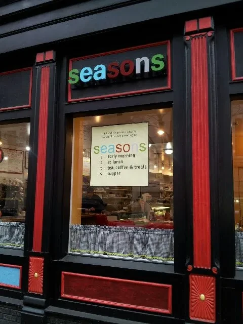 The "seasons" cafe storefront, with black, red, and blue trim.