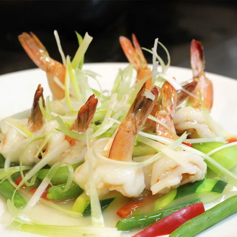 Shrimp tails with sliced green onions and green beans.