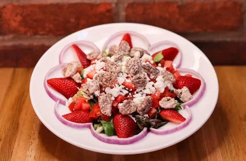 Colorful salad with strawberries, cheese, pecans, and mixed greens.