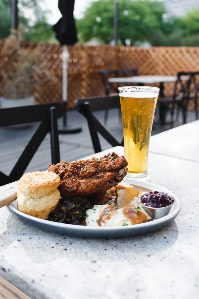 Fried chicken, mashed potatoes, biscuit, greens, relish, and beer.