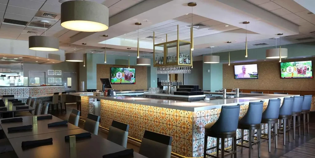 Modern restaurant interior with geometric-tiled bar and dining area.
