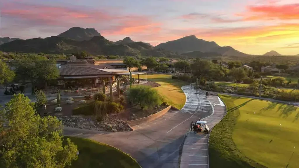 Elevated view: sprawling desert golf clubhouse and landscape at sunset.