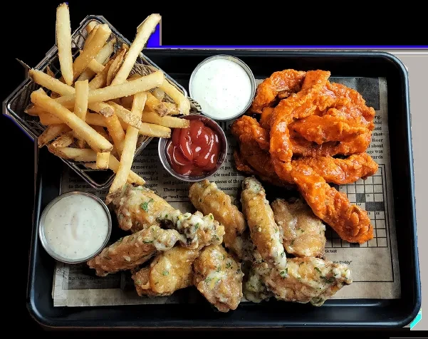 Platter of crispy fries, buffalo and herb chicken wings with dipping sauces.