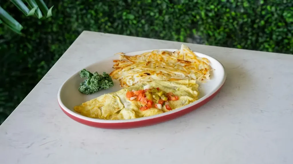 Fluffy omelet with pico de gallo, kale, and golden hash browns.
