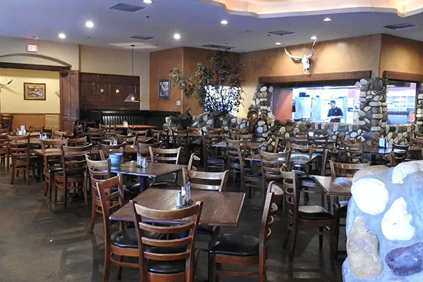 Empty rustic Western dining area with longhorn skull and staff.