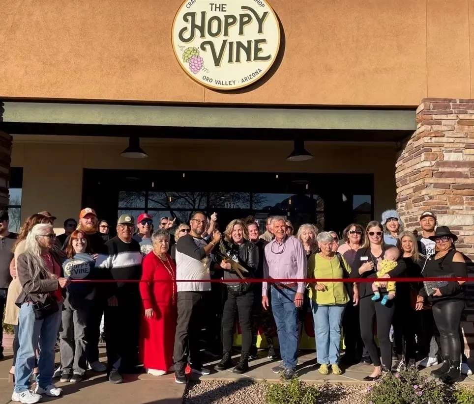Group celebrates ribbon-cutting ceremony in front of The Hoppy Vine.