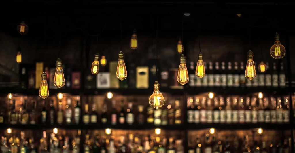 Vintage Edison bulbs glow softly against a blurred bar background.
