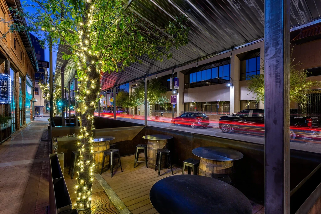 Ten 55 Brewing patio at night with lit tree and city lights.