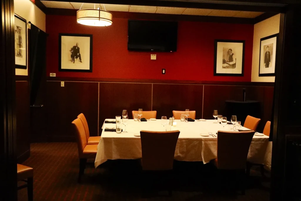 Well-appointed private dining room with a long table set for eight.
