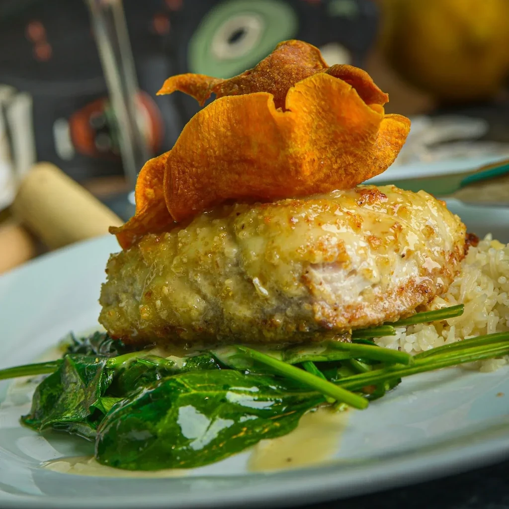 Elegant dish: golden protein, orange crisps, rice, and dark green vegetables.
