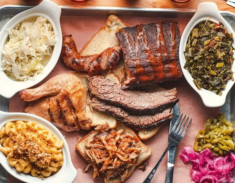 Top-down shot of a large barbecue platter with ribs, brisket, and sides.