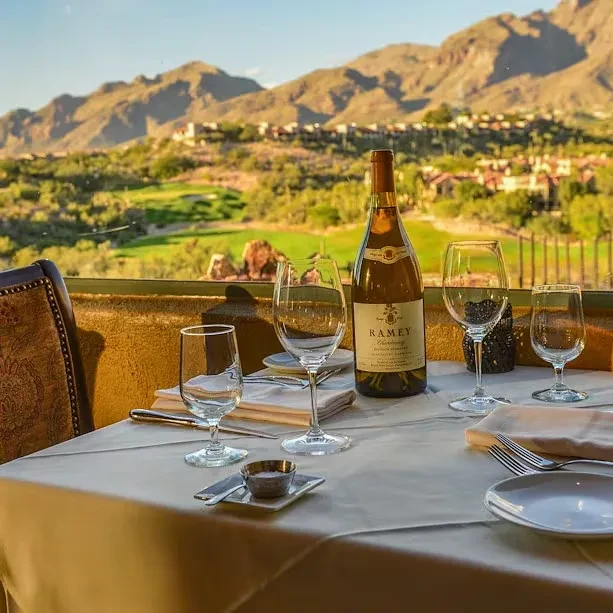 Ramey Chardonnay bottle on table overlooking golf course and mountains.
