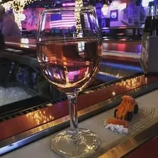 Rosé wine glass, toy bulldozer, American flag in a dim bar.