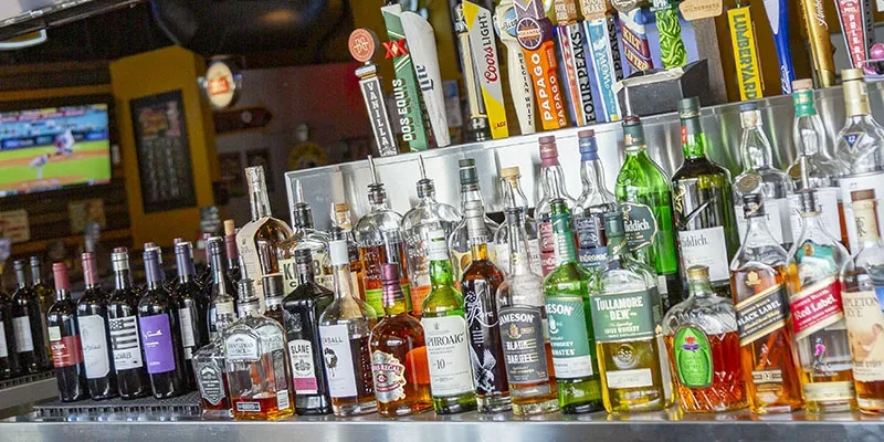 Well-stocked bar counter with liquor bottles and multiple beer taps.