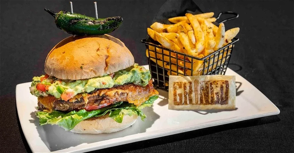 Artfully presented gourmet burger, seasoned fries, and a 'GRINGO' branded cracker.