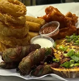 Assorted fried appetizers: onion rings, mozzarella sticks, wings, poppers, loaded fries.