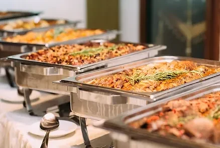 A well-arranged buffet line with multiple chafing dishes of hot food.