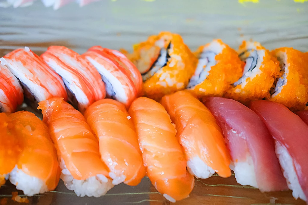 Assortment of salmon and tuna nigiri with imitation crab and tobiko rolls.