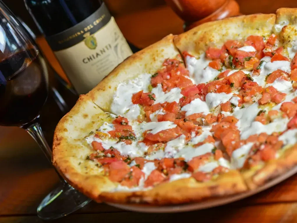 Pizza with tomatoes, cheese, herbs, red wine, and Chianti.