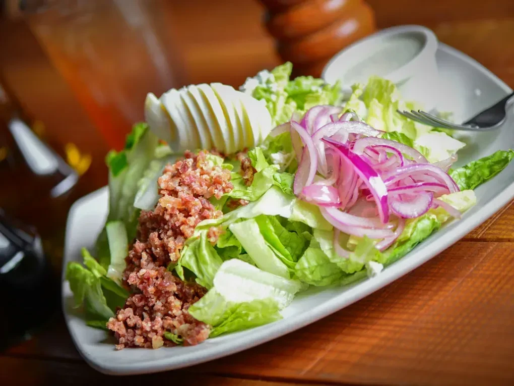 Fresh salad with lettuce, bacon, red onion, hard-boiled egg, blue cheese.