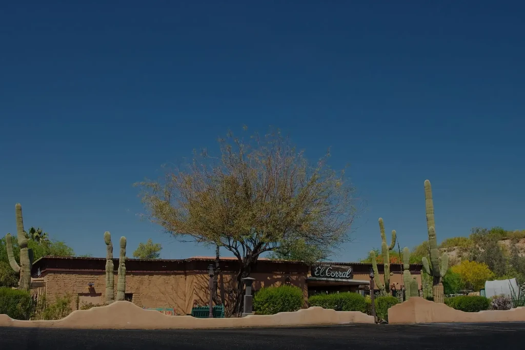 Southwestern El Corral restaurant with adobe walls and Saguaro cacti.