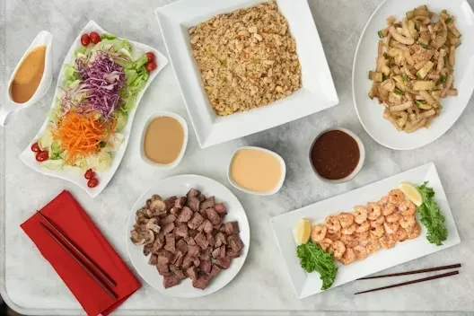 Top-down view of a varied meal spread with several dishes and sauces.