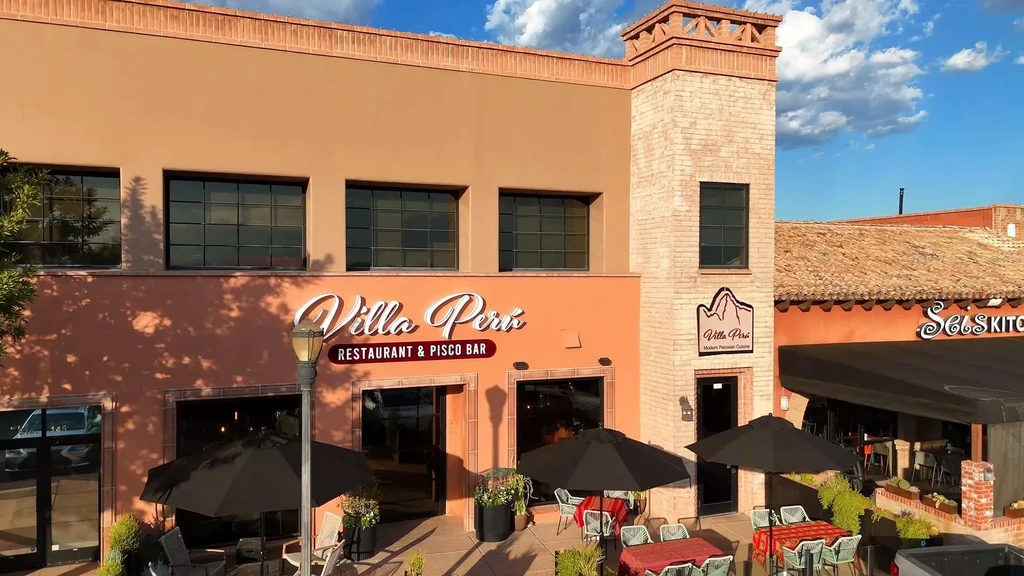 Villa Peru Restaurant: peachy-orange stucco building, brick tower, patio.