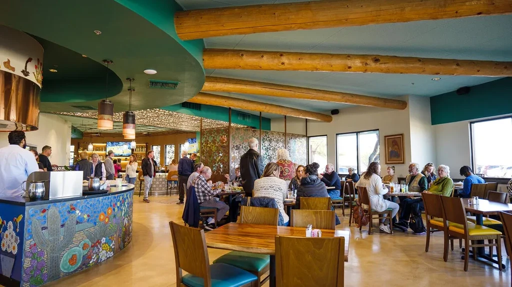 Bustling southwestern restaurant interior with teal ceiling and mosaic cacti counter.