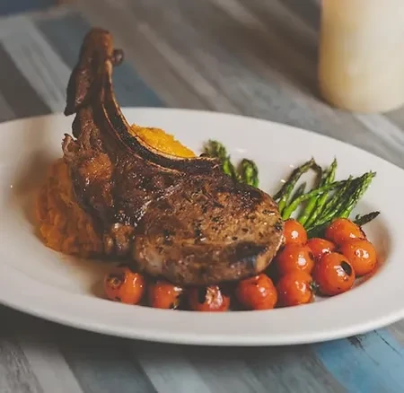 Seared pork chop, sweet potato purée, tomatoes, and asparagus.