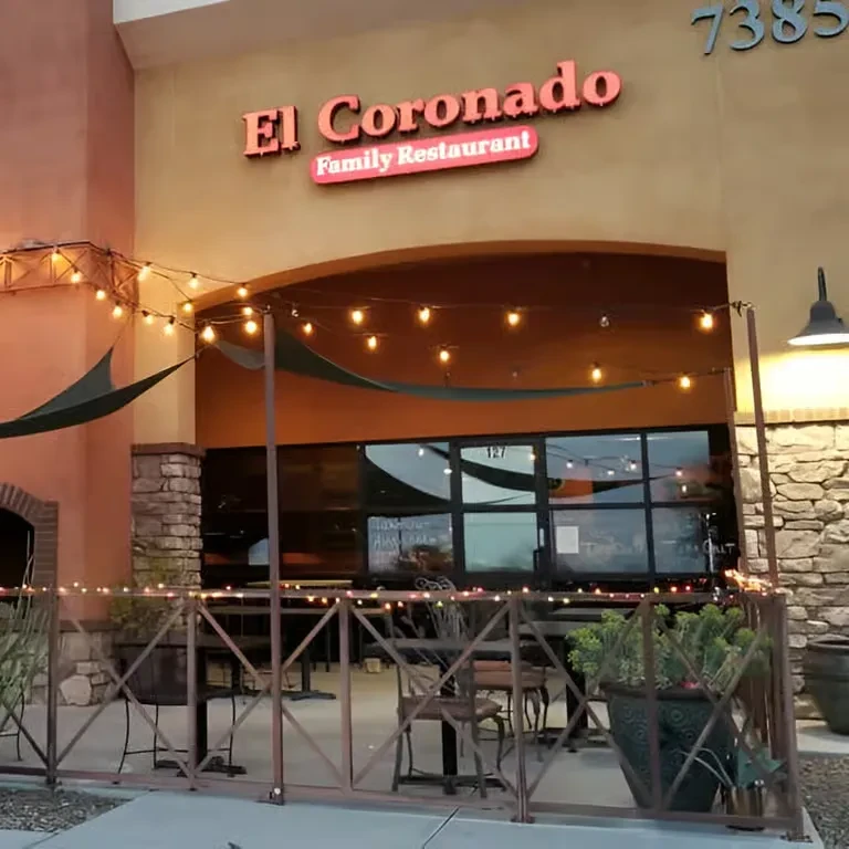 El Coronado Family Restaurant facade with a lit patio and shade sails.
