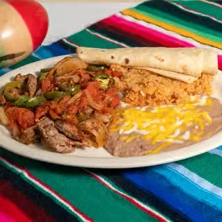 Mexican meal with meat, rice, beans, tortilla on a colorful serape.