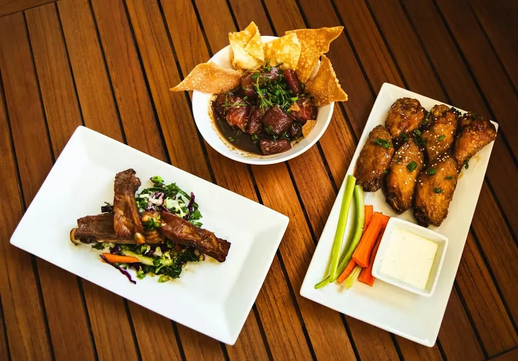 Plated dishes of short ribs, savory stew, and glazed chicken wings.