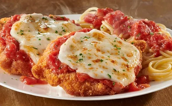 Two chicken parmesan portions with spaghetti and tomato sauce.