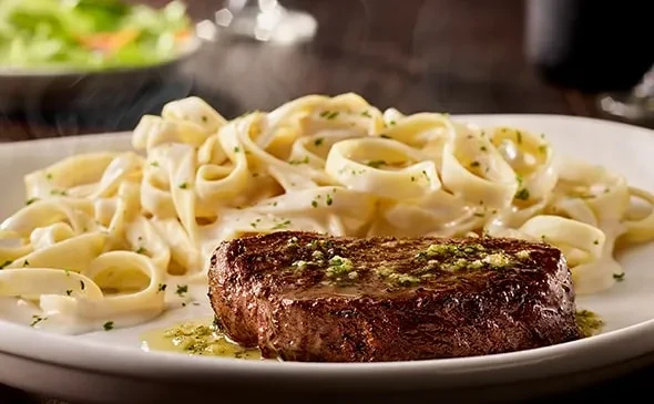 Hot seared steak with herb oil and creamy fettuccine pasta.