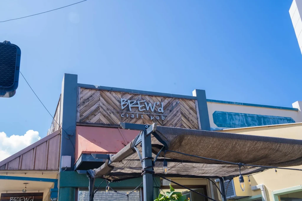 Exterior sign for 'BREW'd craft pub' with chevron wood texture.