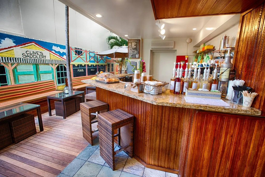 Colorful tropical cafe bar with mural, wooden counter, and seating.
