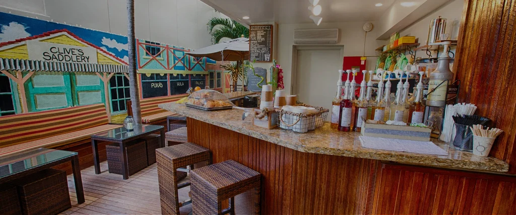 Cafe counter stocked with syrups; vibrant street mural on the wall.