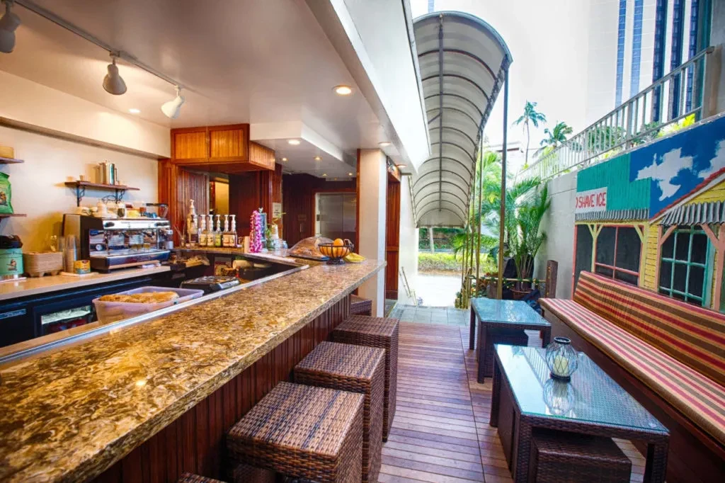 Tropical cafe with granite bar, outdoor patio, and "SHAVE ICE" mural.