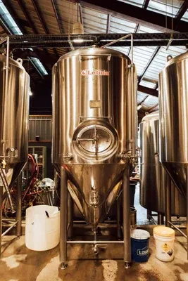 Stainless steel fermentation tanks, including 'Letnia', in a production facility.