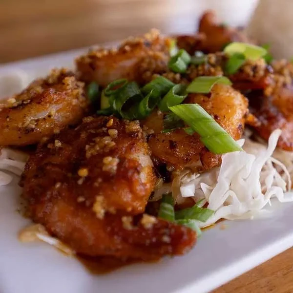 Sautéed shrimp in glossy sauce with garlic, scallions, on cabbage.