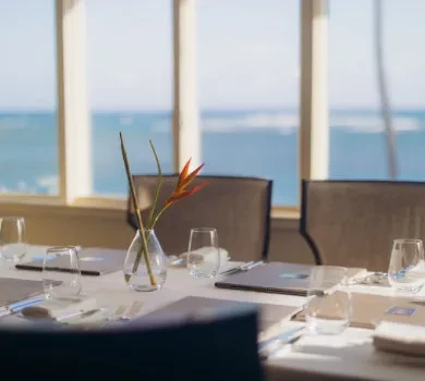 Restaurant table with bird of paradise flower and ocean view.