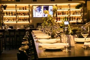 Empty sophisticated bar interior with set counter and illuminated bottles.