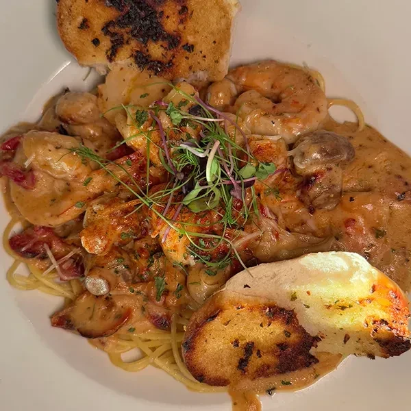 Creamy shrimp pasta with mushrooms, microgreens, and toasted bread.