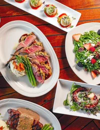 Spread of diverse gourmet dishes on a rustic wooden table.